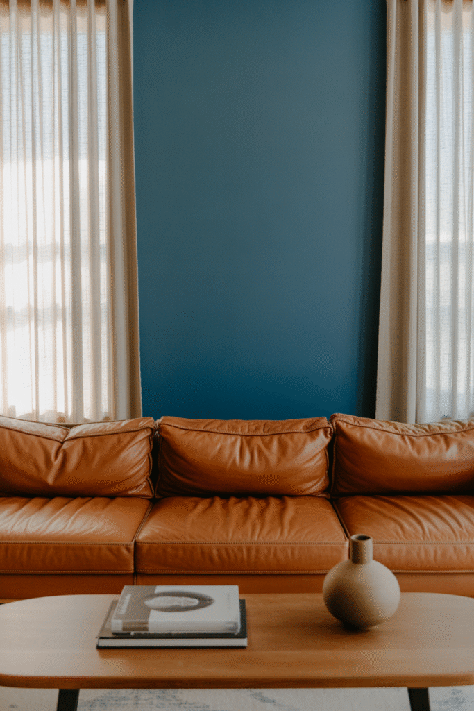 Cozy living room with denim blue accent wall pairs beautifully with leather and wood textures.