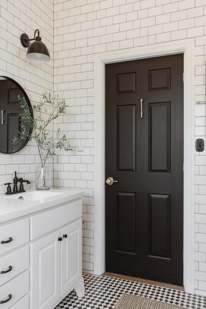 A black-painted bathroom door adds contrast and sophistication.


