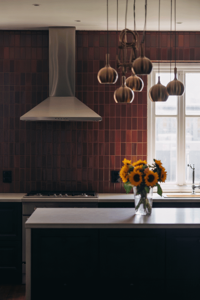 Burgundy backsplash brings rich color and luxury to a dark modern kitchen.