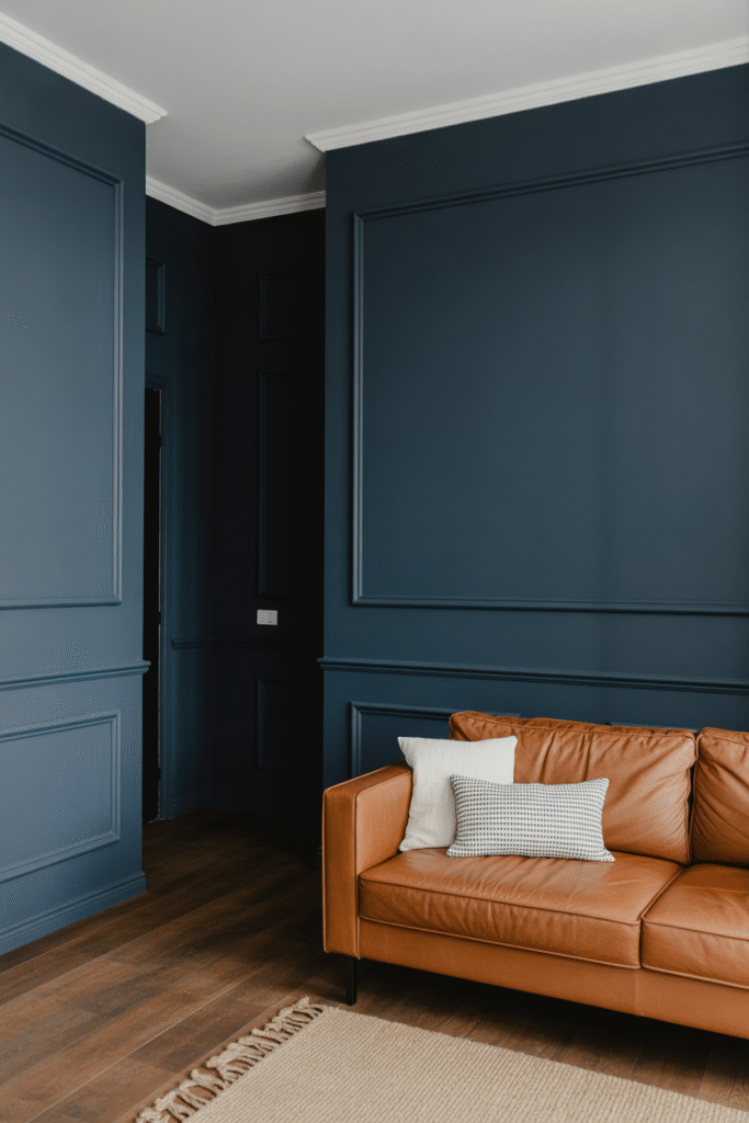 Near-black blue walls with rich depth, softened by warm natural elements.