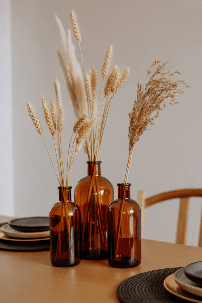 Vintage amber bottles with tall grasses as a fall table centerpiece.
