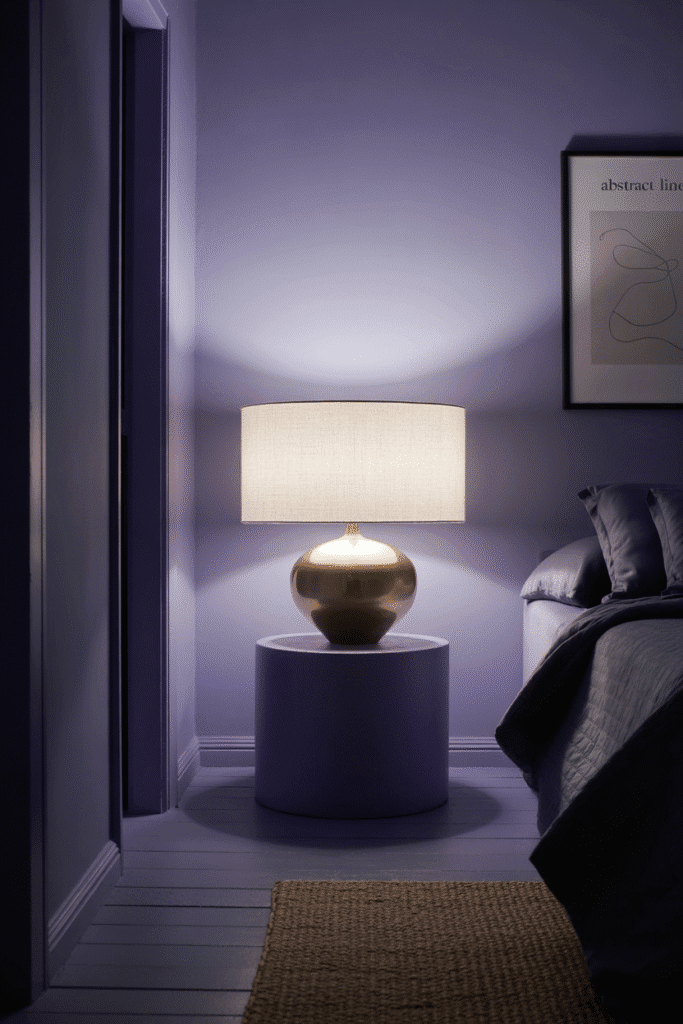 A clean and intentional moody bedroom space with big sidetable lamp.