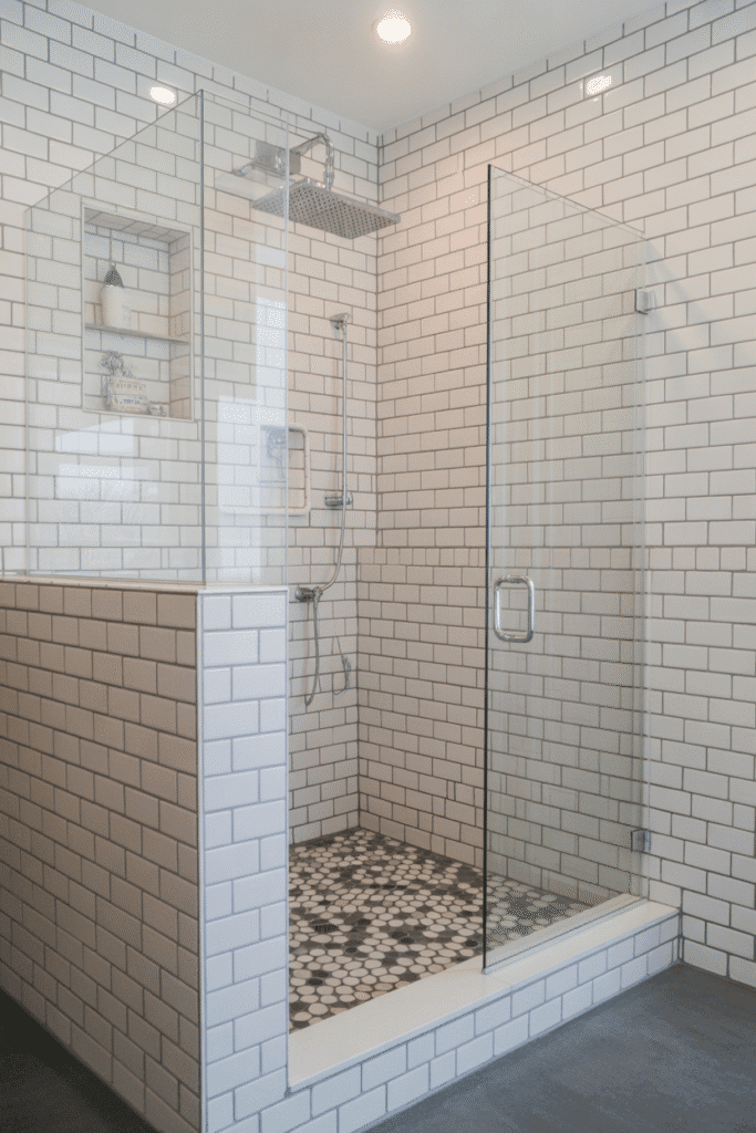 Pebble shower floor in coastal bathroom design.