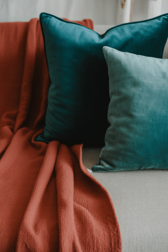 Mid-century modern sofa styled with layered throws and textured cushions.